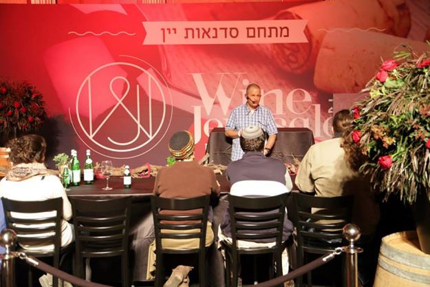 אירוע עם הרצאה על יין, שולחן מעוצב עם כיסאות, ברקע קישוטים וצמחים.