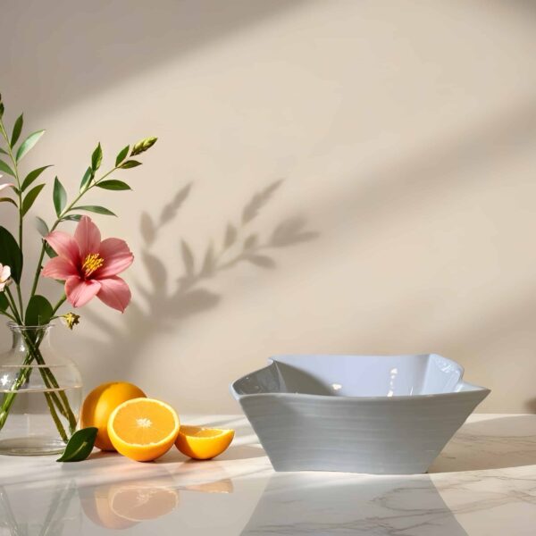 vase עם פרחים, תפוזים חצויים וקערה על שולחן, מתאים לעיצוב שולחנות לאירועים.