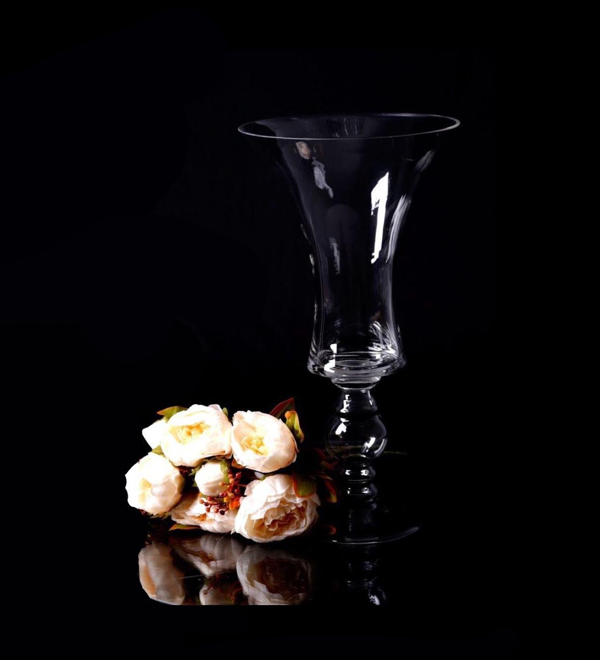 vase שקוף עם מספר 1, לצידו פרחים לבנים, מתאים לעיצוב שולחנות לאירועים.