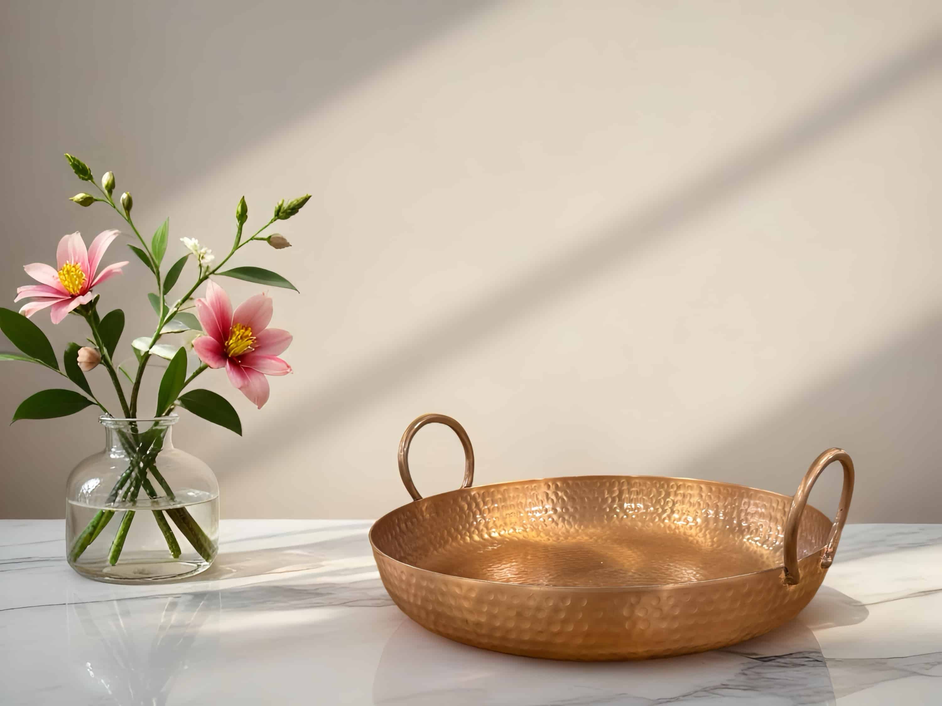 קערת מתכת עם ידיות על שולחן, לצד vase עם פרחים צבעוניים. עיצוב מתאים לאירועים.