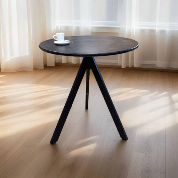 שולחן עגול מעץ עם כוס קפה, מואר באור טבעי, מתאים להשכרת ריהוט לאירועים ולקייטרינג.