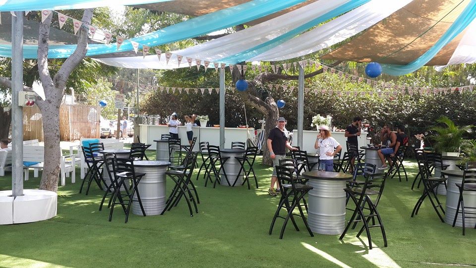 מקום לאירועים עם שולחנות וכסאות, קישוטים צבעוניים ואווירה נעימה לחגיגות.